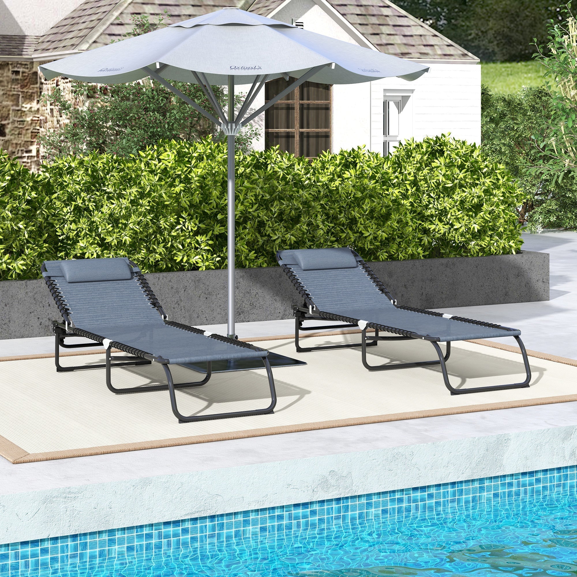 Gray folding chaise lounge pool chairs with adjustable reclining backs and pillows by poolside