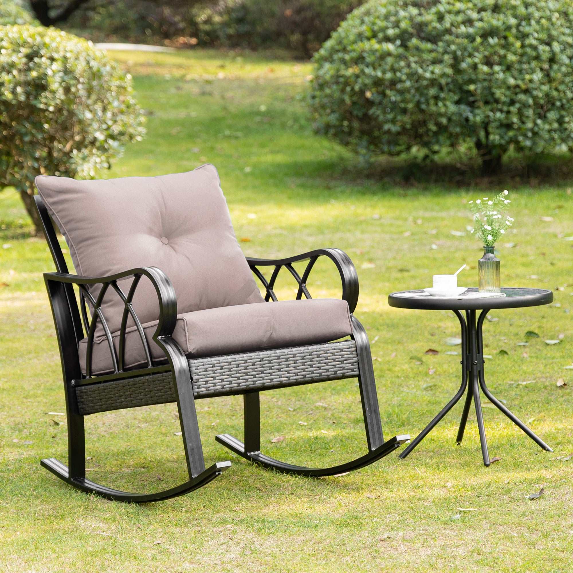 Gray outdoor wicker rocking chair with padded cushions and aluminum frame on patio
