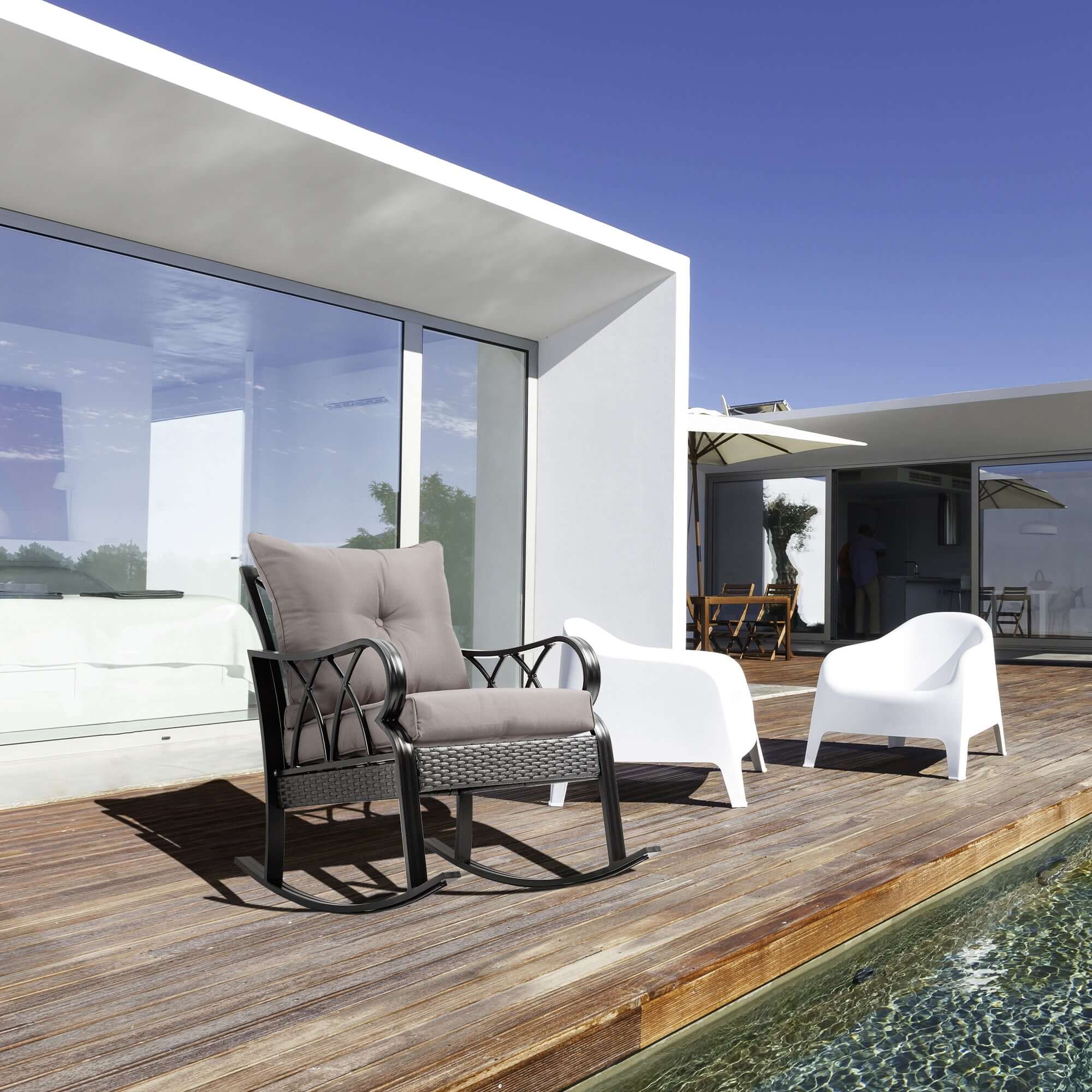 Gray outdoor wicker rocking chair with padded cushions and aluminum frame on patio