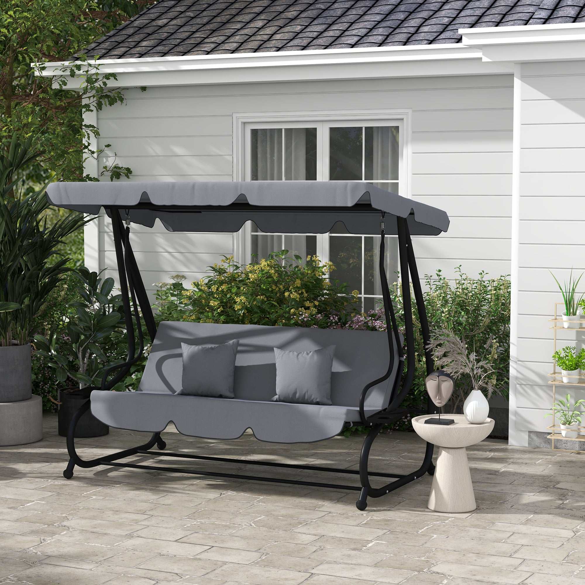 Dark gray free standing swing bench with adjustable canopy, cushions, pillows, and built-in cup holders