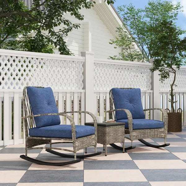 Gray rattan chaise lounge chairs with blue cushions and wicker patio table on outdoor tiled patio