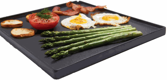 Broil King Exact Fit reversible cast iron griddle with matte porcelain coating cooking eggs, asparagus, tomato, bacon, and toast