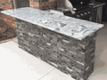 7ft outdoor bar island with stone base and granite countertop with seating overhang