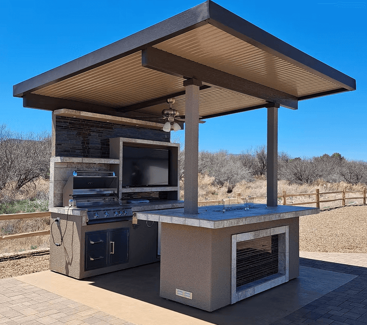 Customizable Baja Outdoor Kitchen Island with patio cover, built-in BBQ grill, storage drawers, outdoor TV, refrigerator, gas fire feature, and bar seating