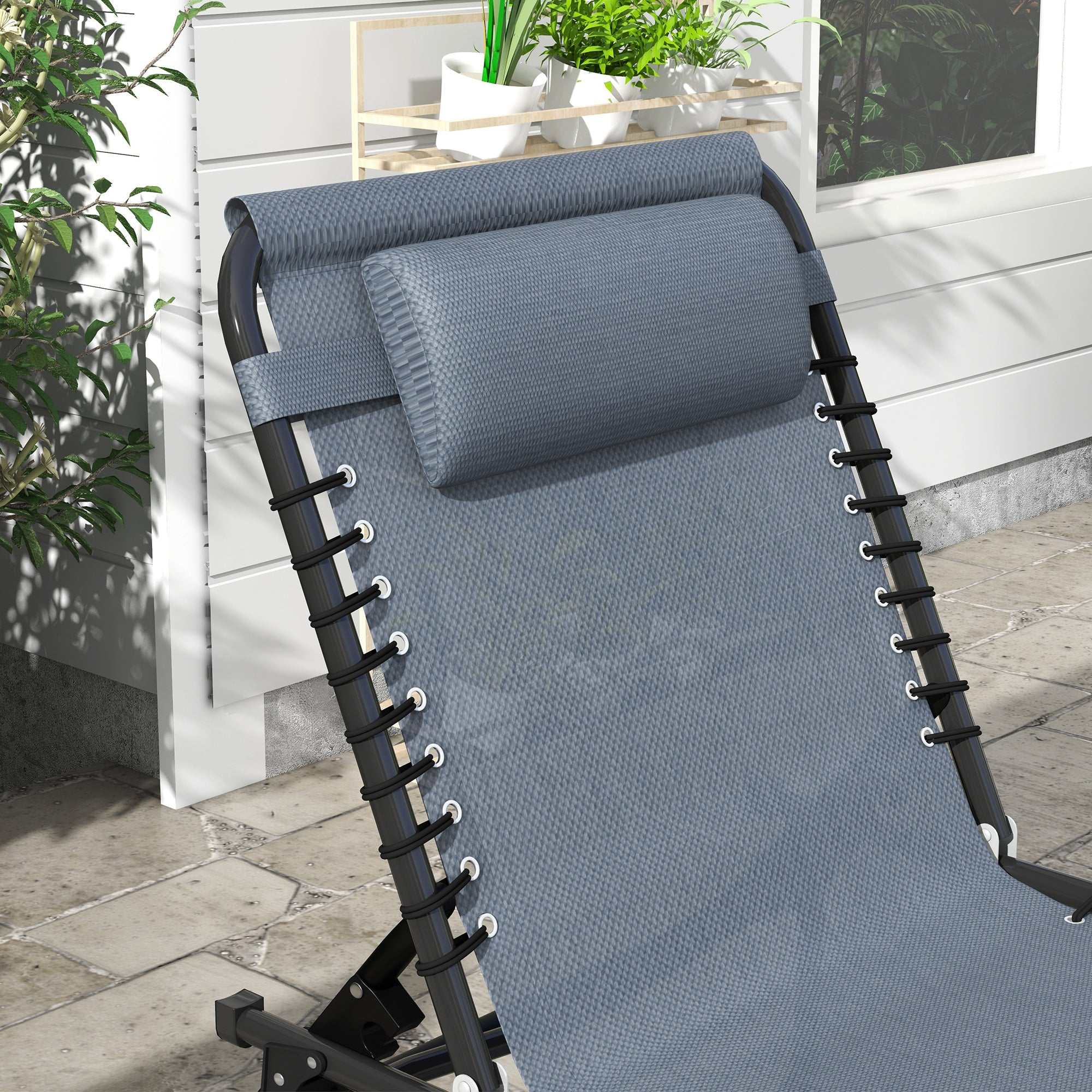 Gray folding chaise lounge with breathable mesh fabric, adjustable pillow, and black steel frame on patio